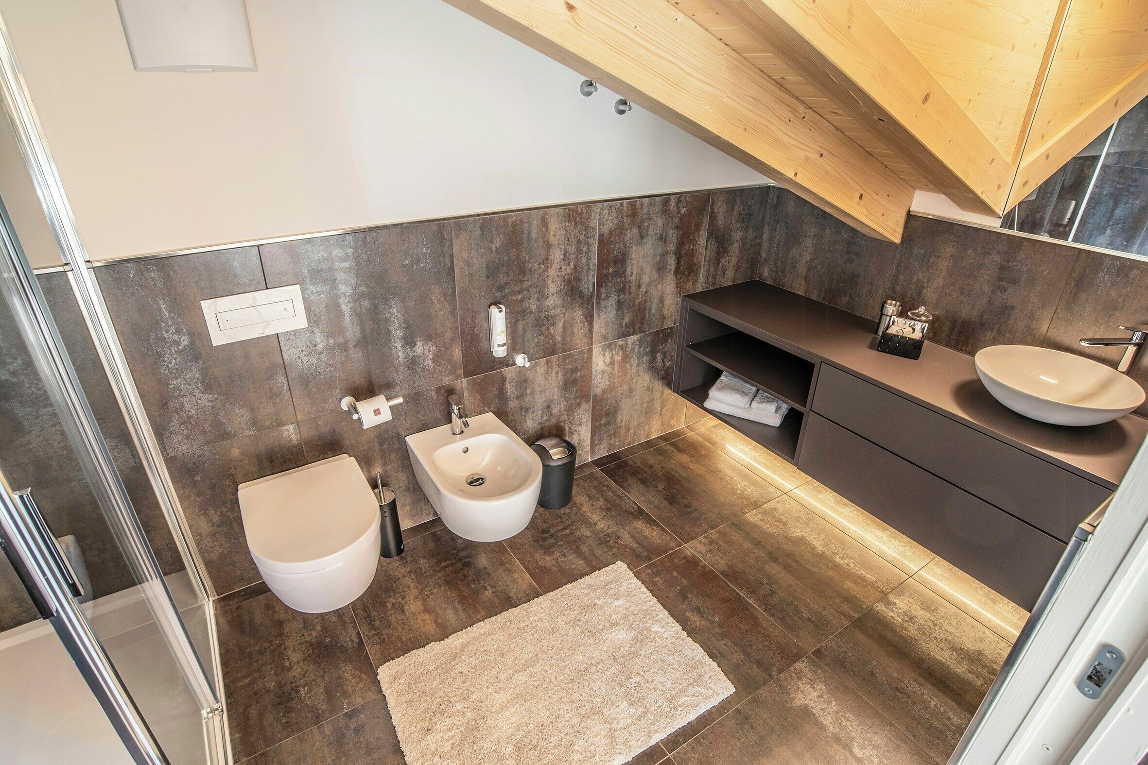 Ein modernes Badezimmer mit einer Bidet, Waschbecken und Waschtisch.