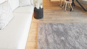 A modern interior with a wooden ceiling, a white sofa, a dining area with chairs, and a kitchen in the background. - Alpine flats in Fai della Paganella (Fai della Paganella)