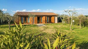 A modern house with a tiled roof, large windows, and a well-maintained lawn. - Orlando. Villa with private pool near Lucca (Colle di Compito)