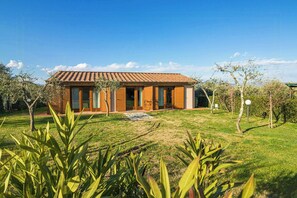 Ein modernes Haus mit Ziegeldach, großen Fenstern und einem gepflegten Rasen.
