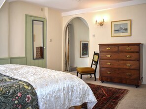A bedroom with a bed, dresser, chair, and a mirror. - 2 bedroom accommodation in Bampton (Bampton)