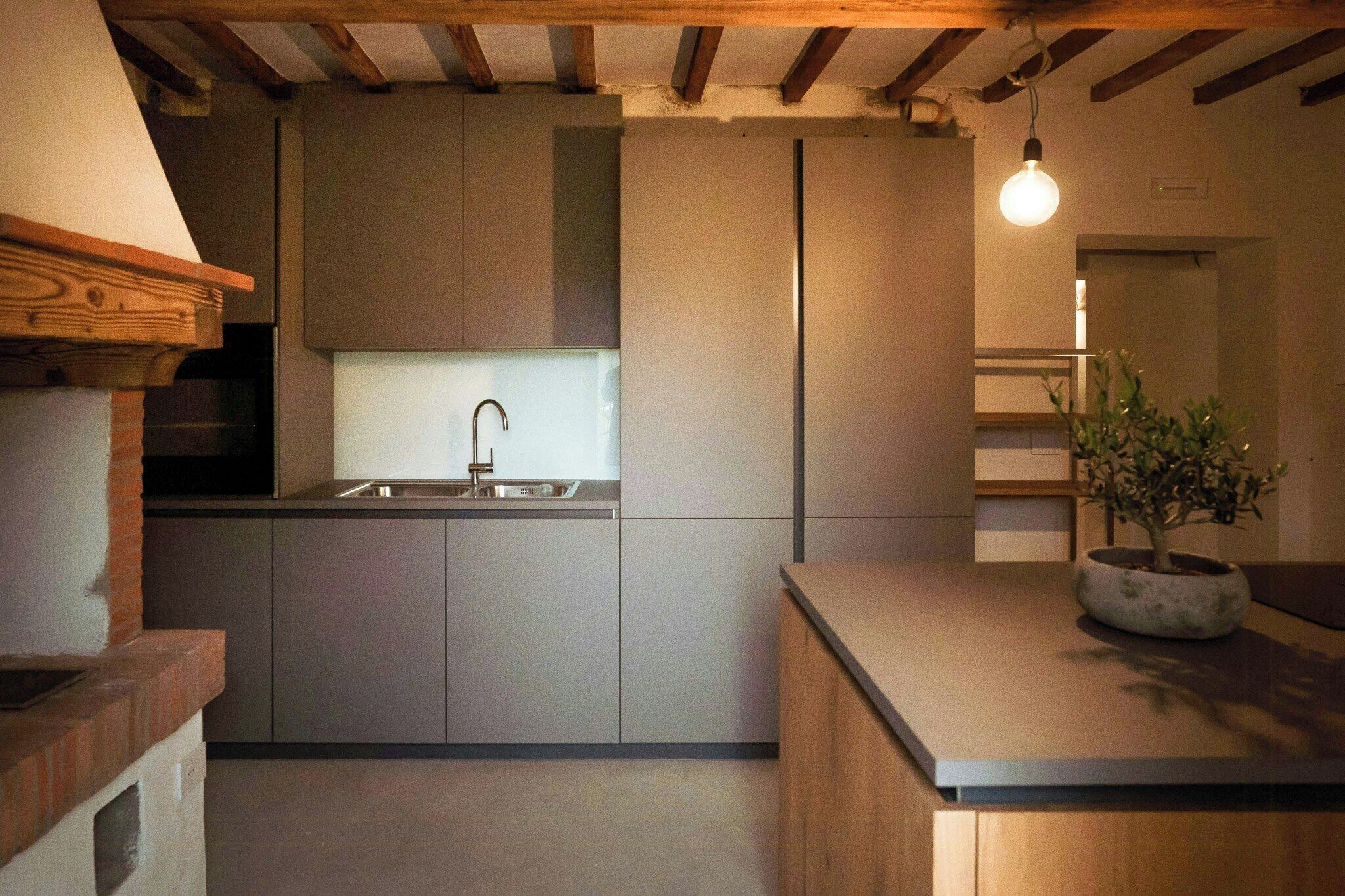 Une cuisine moderne dotée d’un four encastré, d’un évier et d’un plan de travail en bois.