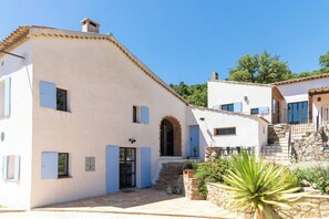 A white building with blue shutters, a stone staircase, and a small garden with a cactus. - Historic Provençal farmhouse with pool in Provence (Le Plan-de-la-Tour)