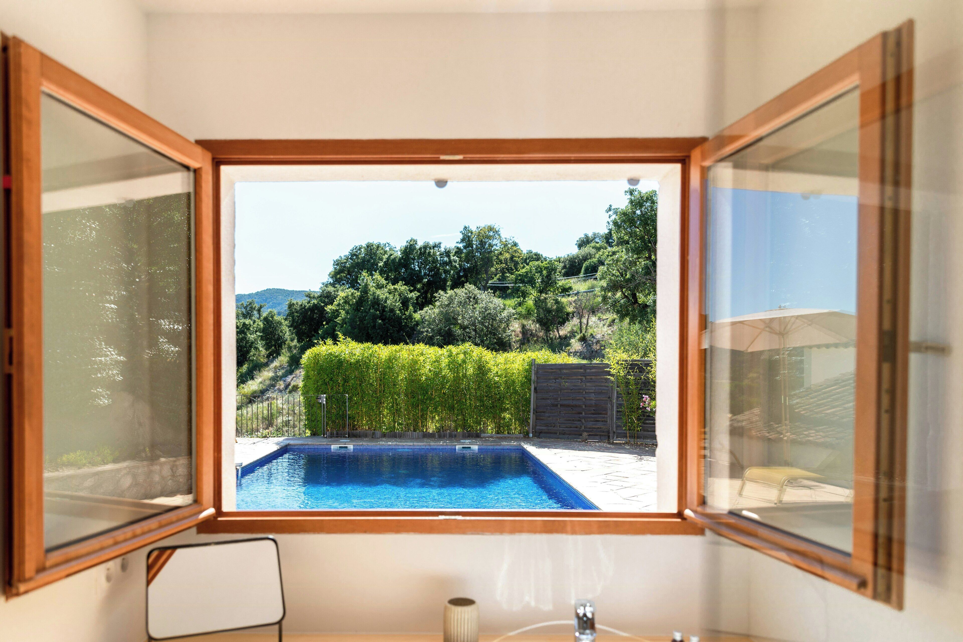 Ein Zimmer mit Blick auf einen Swimmingpool, einen Stuhl und einen Tisch.