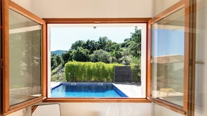 Ein Zimmer mit Blick auf einen Swimmingpool, einen Stuhl und einen Tisch.