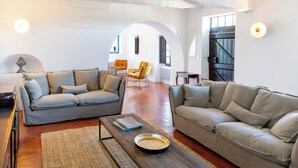 Ein Wohnzimmer mit zwei Sofas, einem Couchtisch und einem Teppich.