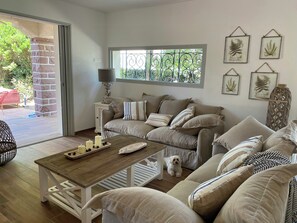 Ein gemütliches Wohnzimmer mit einer Couch, einem Couchtisch und einem Hund.