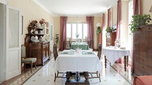 Une salle à manger avec une table dressée pour quatre personnes, bordée de meubles et de chaises en bois.
