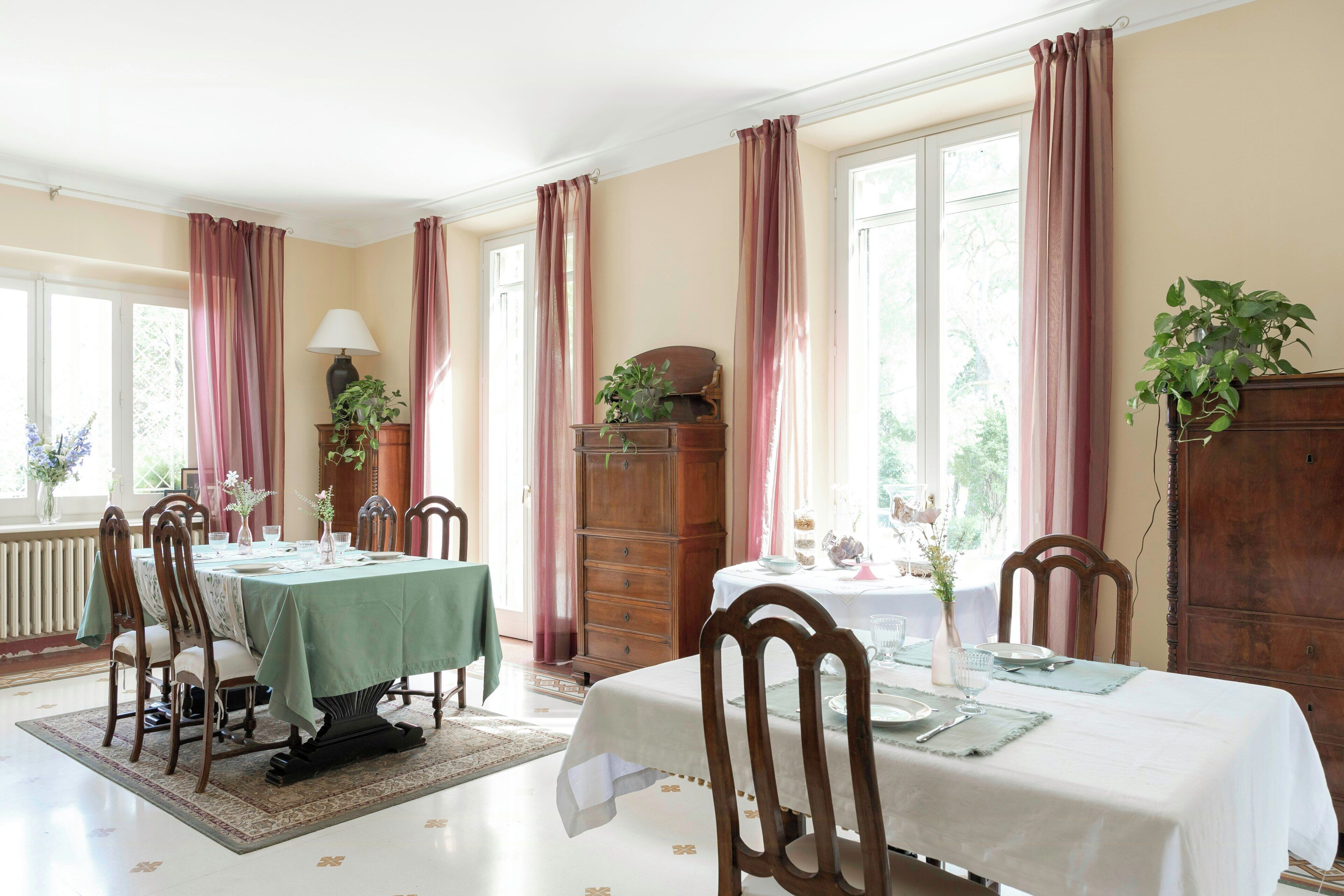 Een eetkamer met een tafel voor vier personen, een houten kast en een radiator.