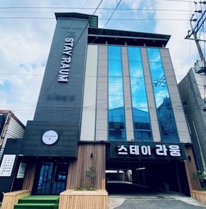 A modern building with a sign reading 'STAY RAUM' and another sign in a different language. - Gumi Stay Raum (Gumi)