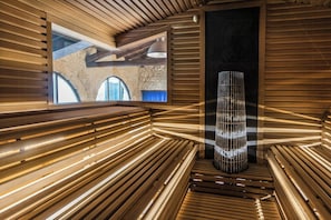 Ein modernes Interieur mit Holzleisten, einer zentralen Leuchte und Blick auf eine äußere Steinarchitektur.