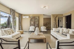 A spacious living room with a sofa set, two armchairs, a coffee table, and a decorative wall piece. - Mediterranean villa with French Riviera views (Cabris)