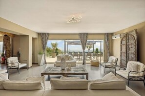 A spacious living room with a large window, a ceiling light fixture, and a view of the outdoors. - Mediterranean villa with French Riviera views (Cabris)
