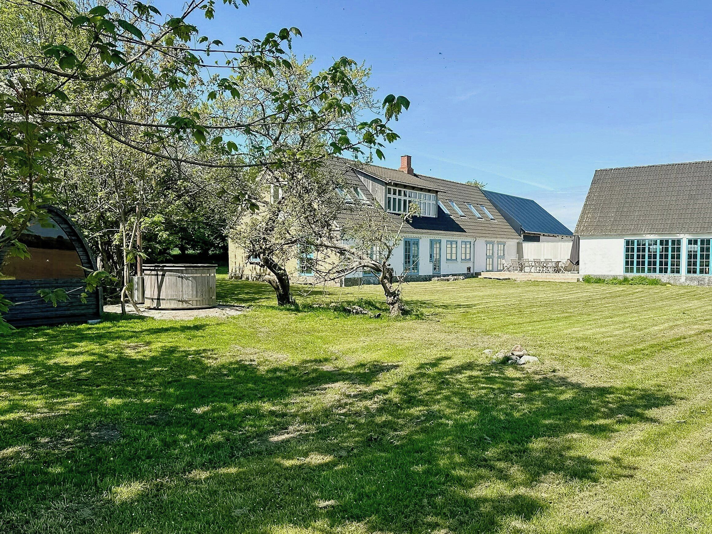 A house with a large lawn, a tree, and a shed.