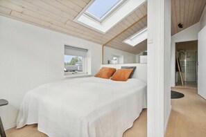 Un dormitorio con tragaluz, una cama y vistas al exterior.
