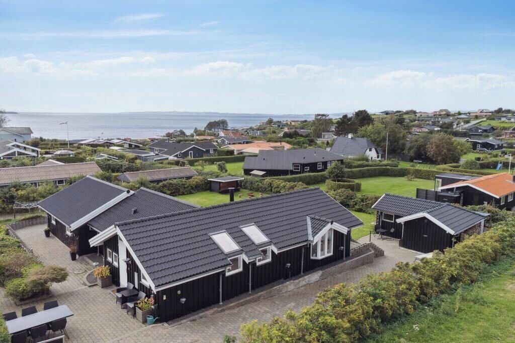 Un quartier résidentiel avec des maisons, une allée pavée et une vue sur la mer.