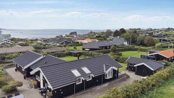 Un quartier résidentiel avec des maisons, une allée pavée et une vue sur la mer.
