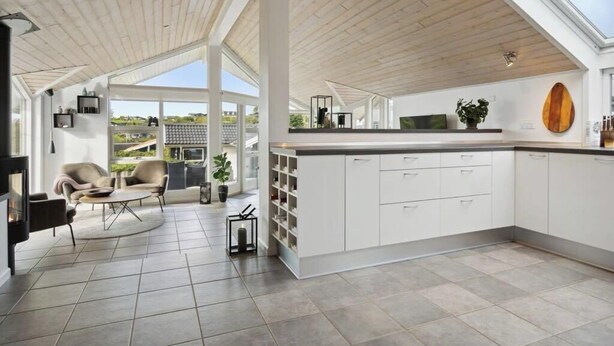 A modern kitchen with white cabinetry, a large island, and a view of the outdoors.