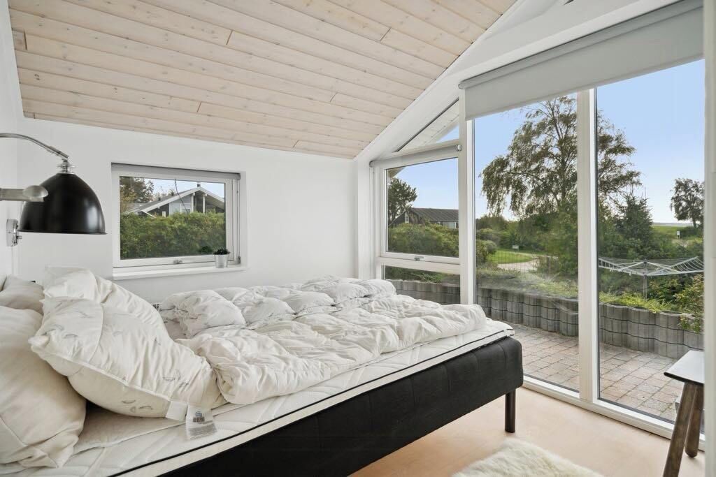 Une chambre à coucher avec un lit, une fenêtre et une vue sur l’extérieur.