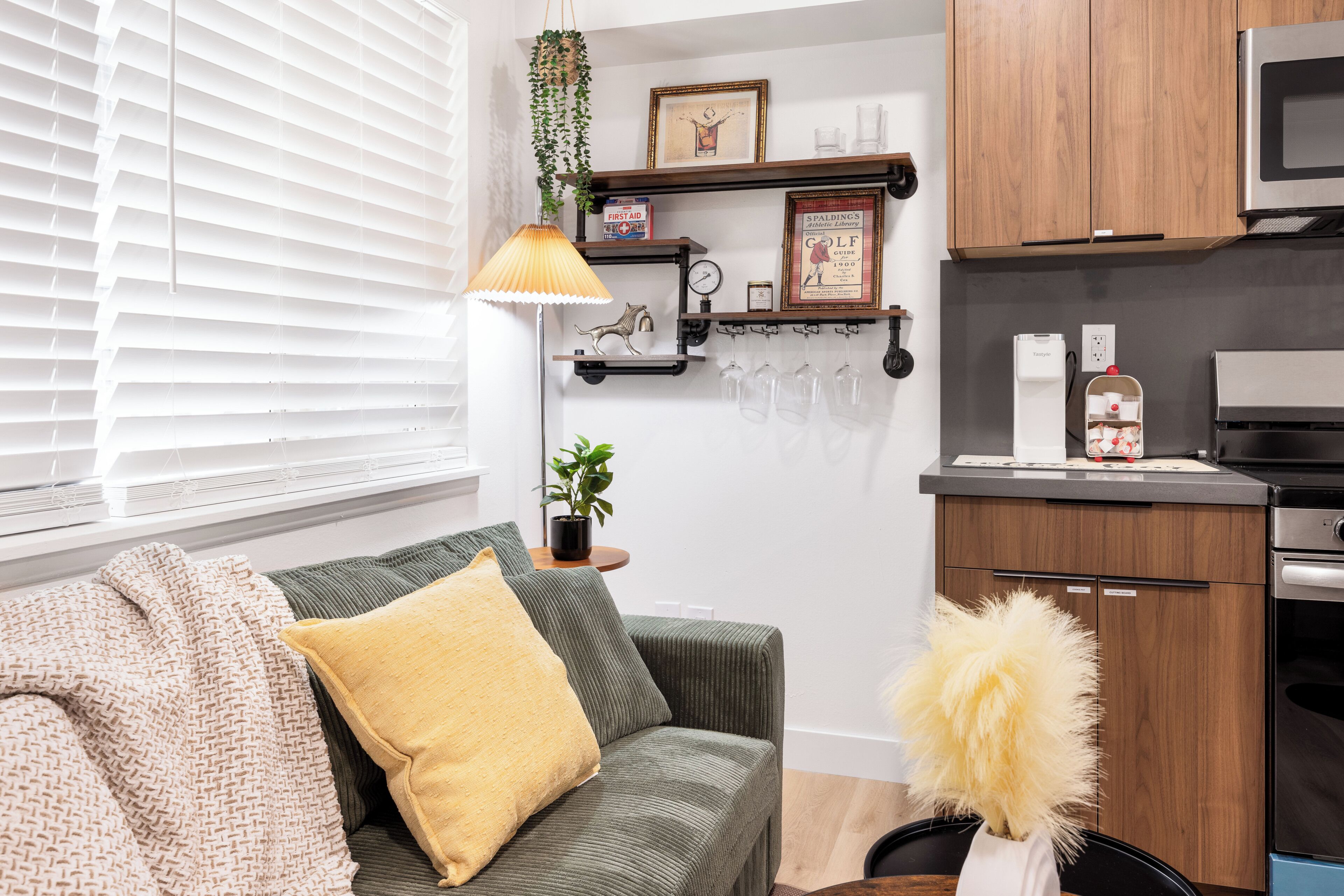 A modern kitchen with wooden cabinets, a microwave, and a coffee machine.