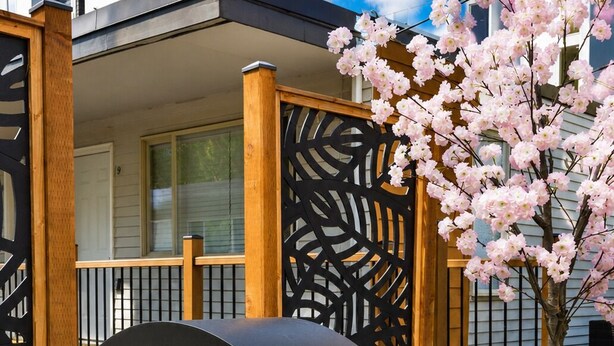 A garden with a water feature, a wooden fence, and flowering plants. - STAYOO SUITES-Seattle Secret Garden (Seattle)