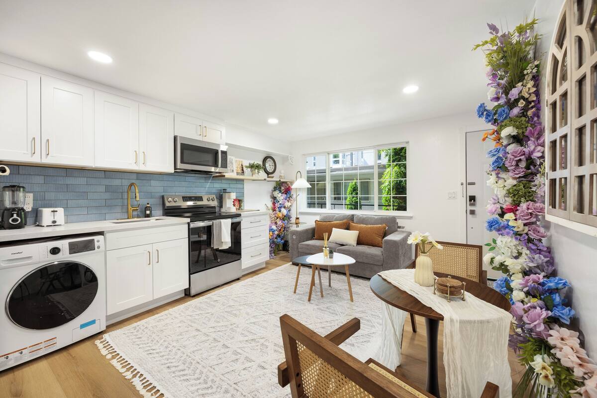 A modern kitchen with white cabinets, a built-in oven, and a microwave.