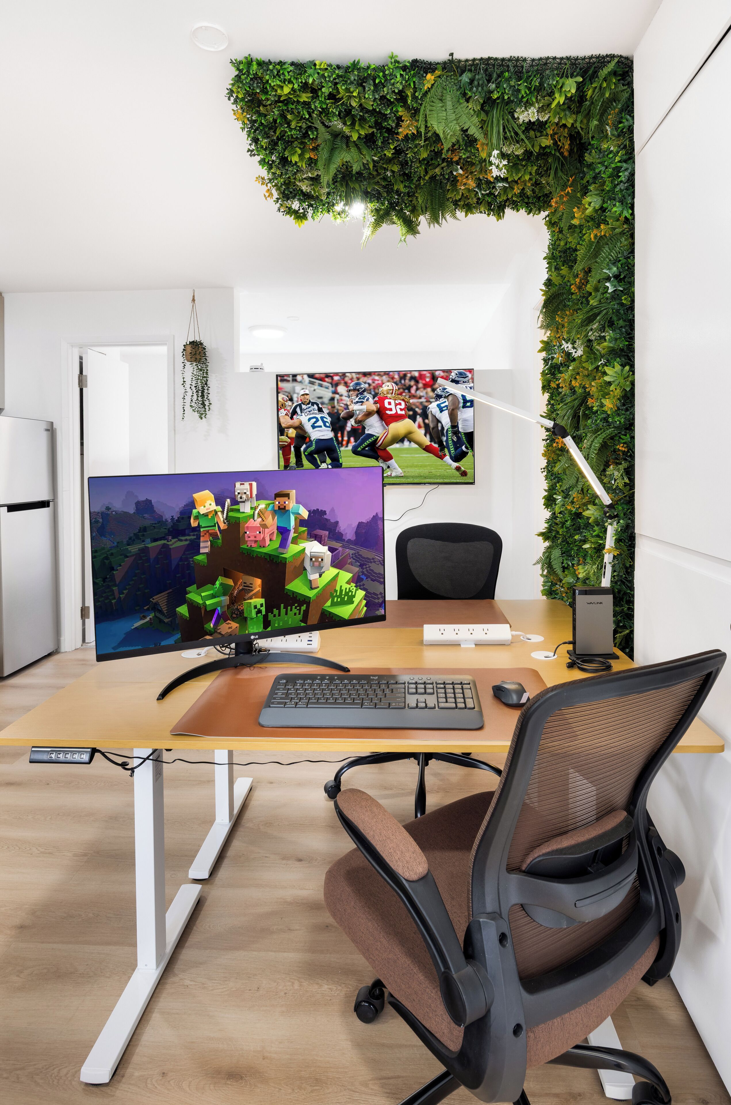 Uma mesa de escritório moderna com monitor de computador, teclado e cadeira.