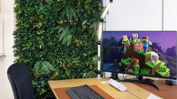 Un espace de travail comprenant un écran d’ordinateur affichant une scène de Minecraft, un clavier, une souris et une chaise.