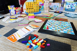 Una variedad de juegos de mesa y juguetes esparcidos sobre una alfombra.