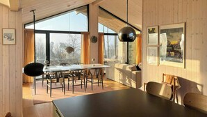 A modern kitchen with a large island, dining area, and large windows. - Summer house by Mols Bjerge Trail with sea view (Knebel)