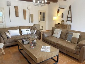 A living room with two brown leather sofas, a wooden coffee table, and a chandelier. - Provençal mansion in the heart of Luberon (Murs)