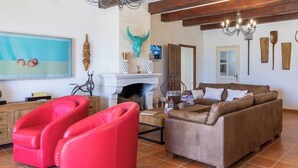 A living room with a fireplace, a sofa, and a red chair.