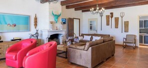 A living room with a fireplace, a sofa, and a red chair. - Provençal mansion in the heart of Luberon (Murs)