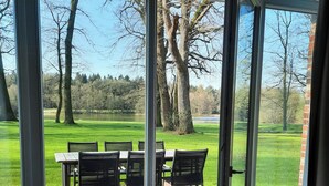 A room with a sliding glass door leading to an outdoor patio with a table and chairs. - Forestry chic: flat with lake and forest view (Friedeburg)