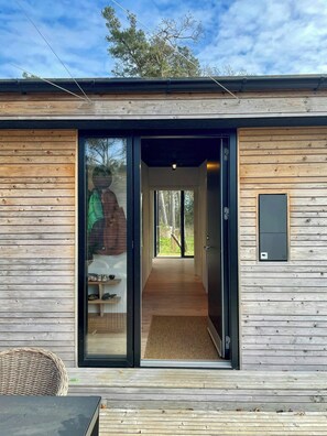 A wooden exterior with a glass door leading to a hallway. - Holiday home with forest view 200 m from beach (Tved)