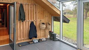 Een houten interieur met een schuifglazen deur die uitkomt op een gazon.