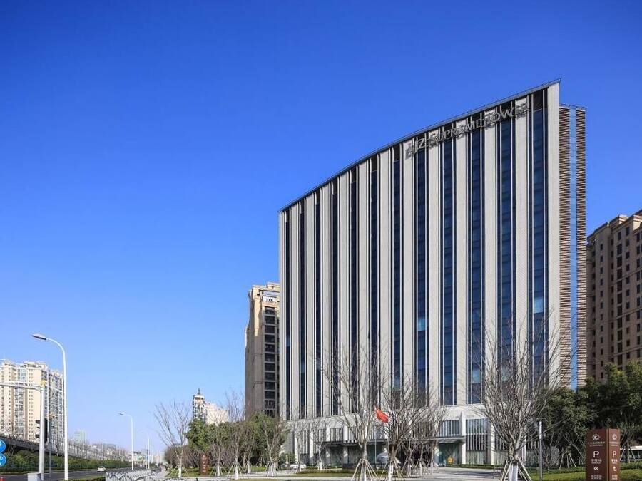 A modern building with vertical lines, a clear sky, and a parking sign.
