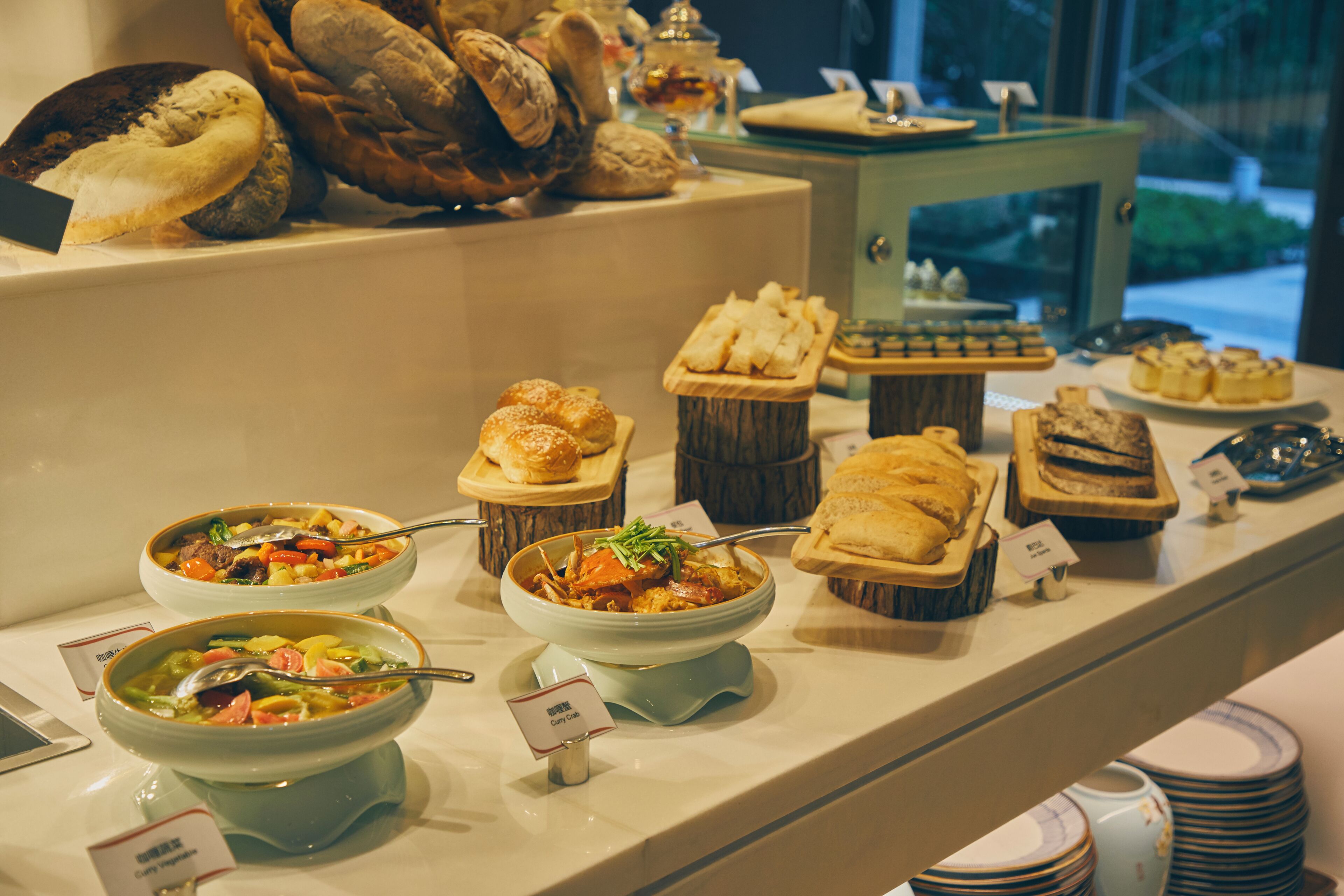 A buffet with various dishes, including soups, pastries, and bread.