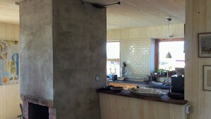 Una cocina con horno de ladrillo, armarios de madera y una zona de bar.