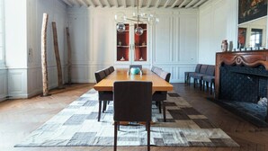 A dining room with a wooden table, chairs, a chandelier, and a fireplace. - 18th-century estate between Bordeaux and Sauternes (Saint-Côme)