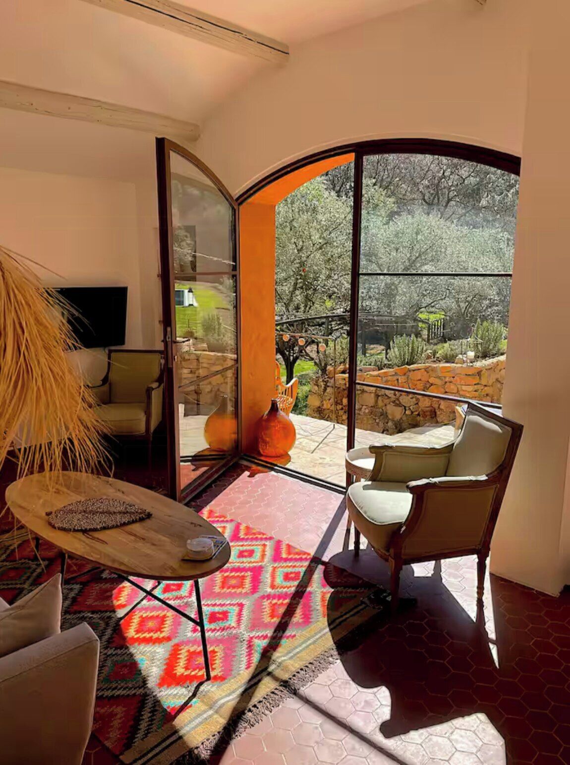 A modern interior with a large glass door leading to an outdoor patio area.