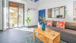 A living room with a sofa, a coffee table, and a large window. - CASA DE PUEBLO en el CENTRO de Roses, al lado de la playa con TERRAZA (Roses)