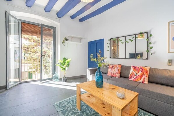 Ein Wohnzimmer mit einer Couch, einem Couchtisch und einem großen Fenster.
