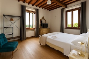 A bedroom with a bed, a dresser, a chair, and a window with curtains. - Villa with pool in the Arezzo countryside (Arezzo)