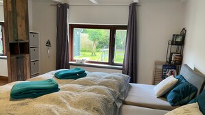 Una camera da letto con un letto, una finestra, un termosifone, una libreria e vista all'esterno.