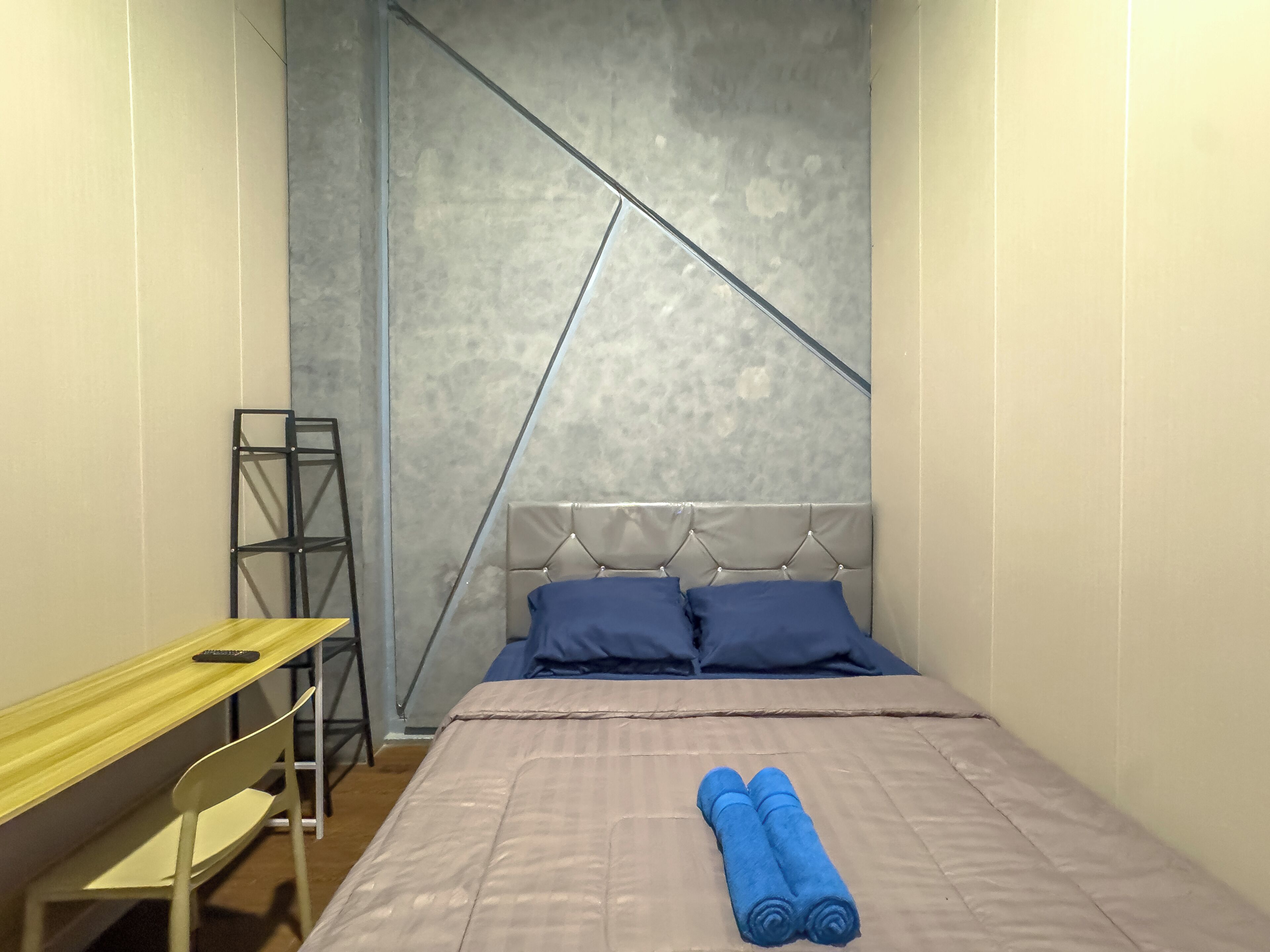 Ein Schlafzimmer mit einem Bett, einem Schreibtisch und einem Stuhl.