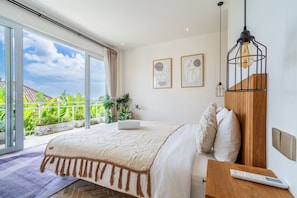 Een slaapkamer met een groot raam, een bed, een nachtkastje en een afstandsbediening.