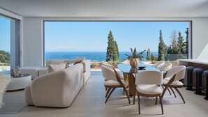 A modern living room with a large glass door leading to a balcony with a sea view. - Doci Kelios Villa with heated pool (Zakynthos)