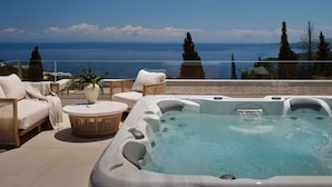 A rooftop terrace with a hot tub, lounge chairs, and a view of the sea. - Doci Kelios Villa with heated pool (Zakynthos)