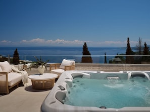 A rooftop terrace with a hot tub, lounge chairs, and a view of the sea. - Doci Kelios Villa with heated pool (Zakynthos)